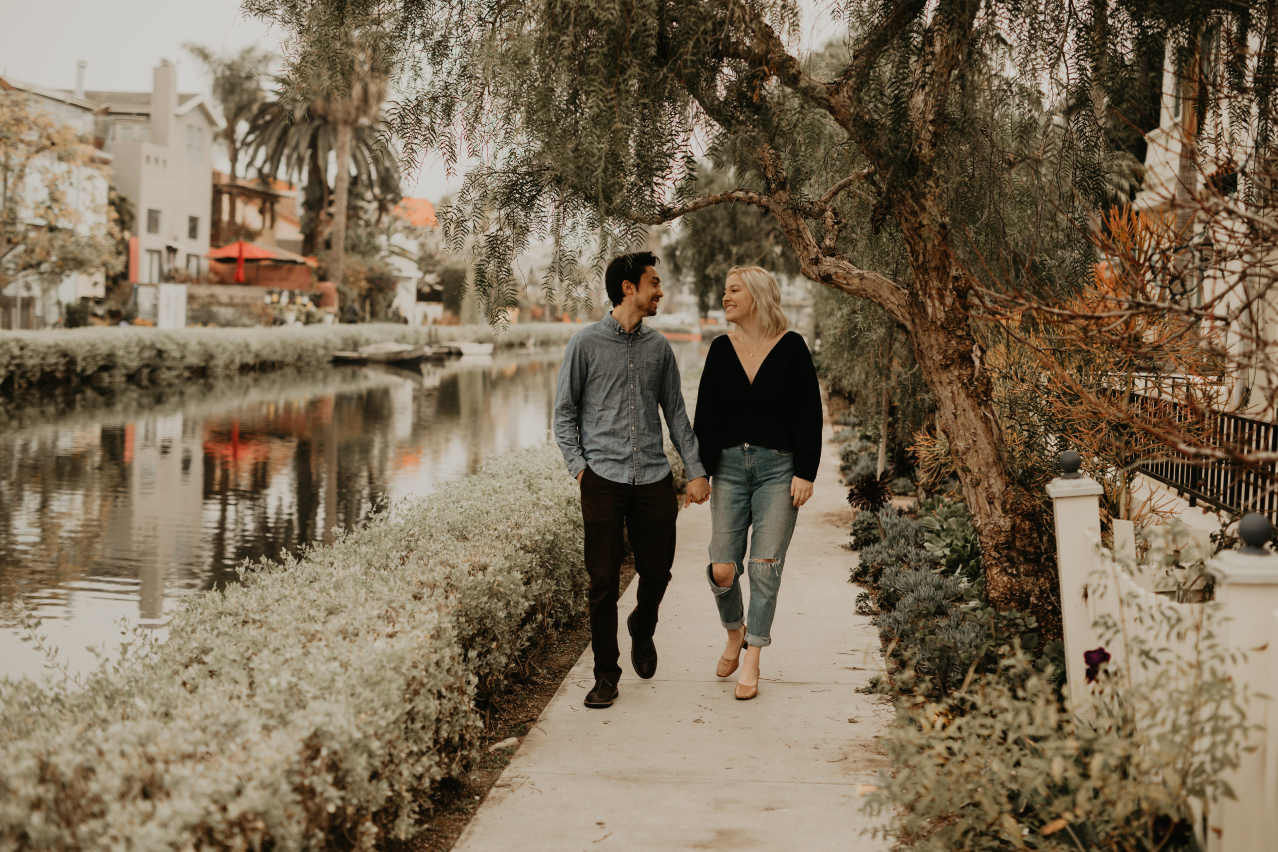 Couple walks at Venice Canals in Los Angeles, California