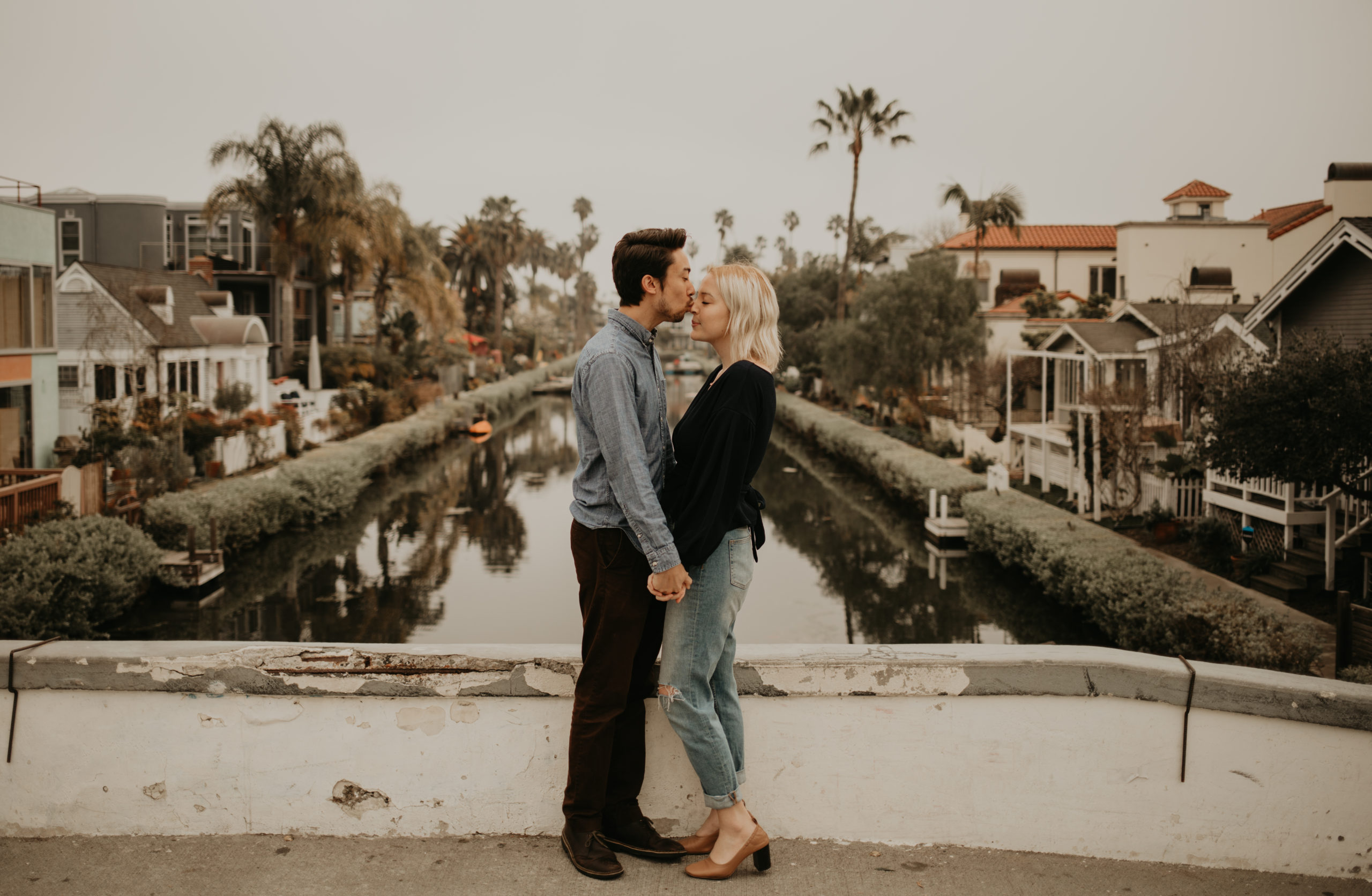 Couple kisses during couple session with Cara Gilhula Photography at Venice Canals, California