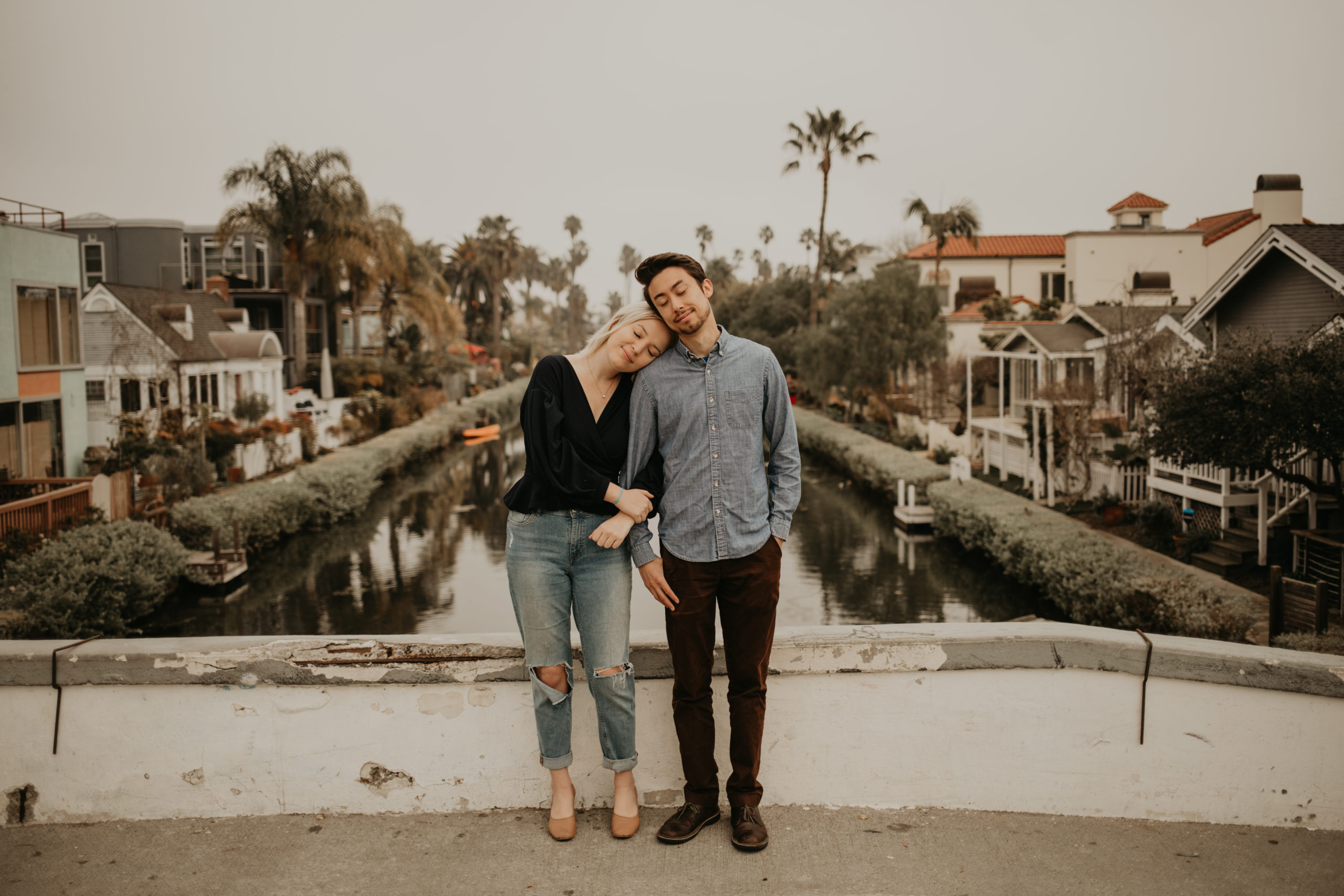 Couple closes eyes during couple session with Cara Gilhula Photography at Venice Canals, California