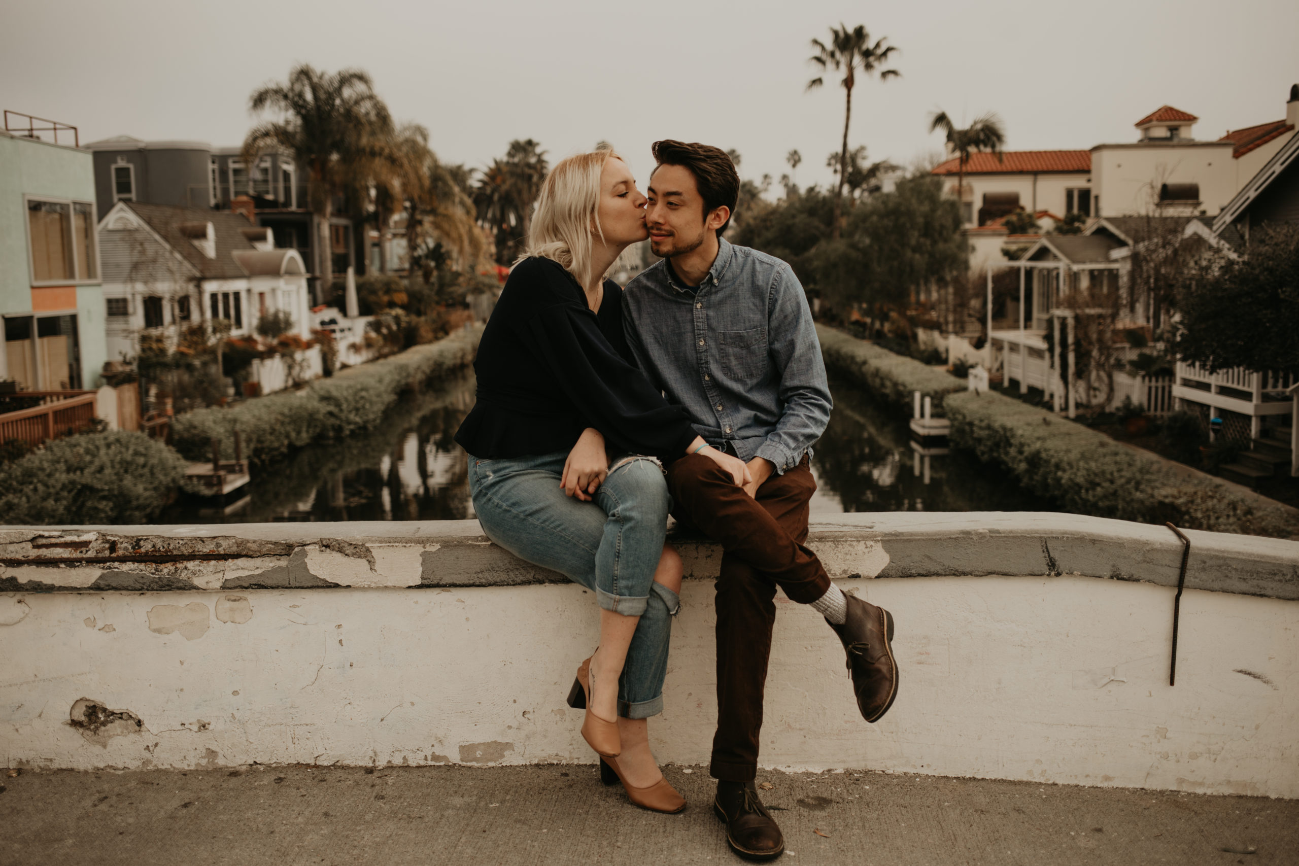 Couple kisses during couple session with Cara Gilhula Photography at Venice Canals, California