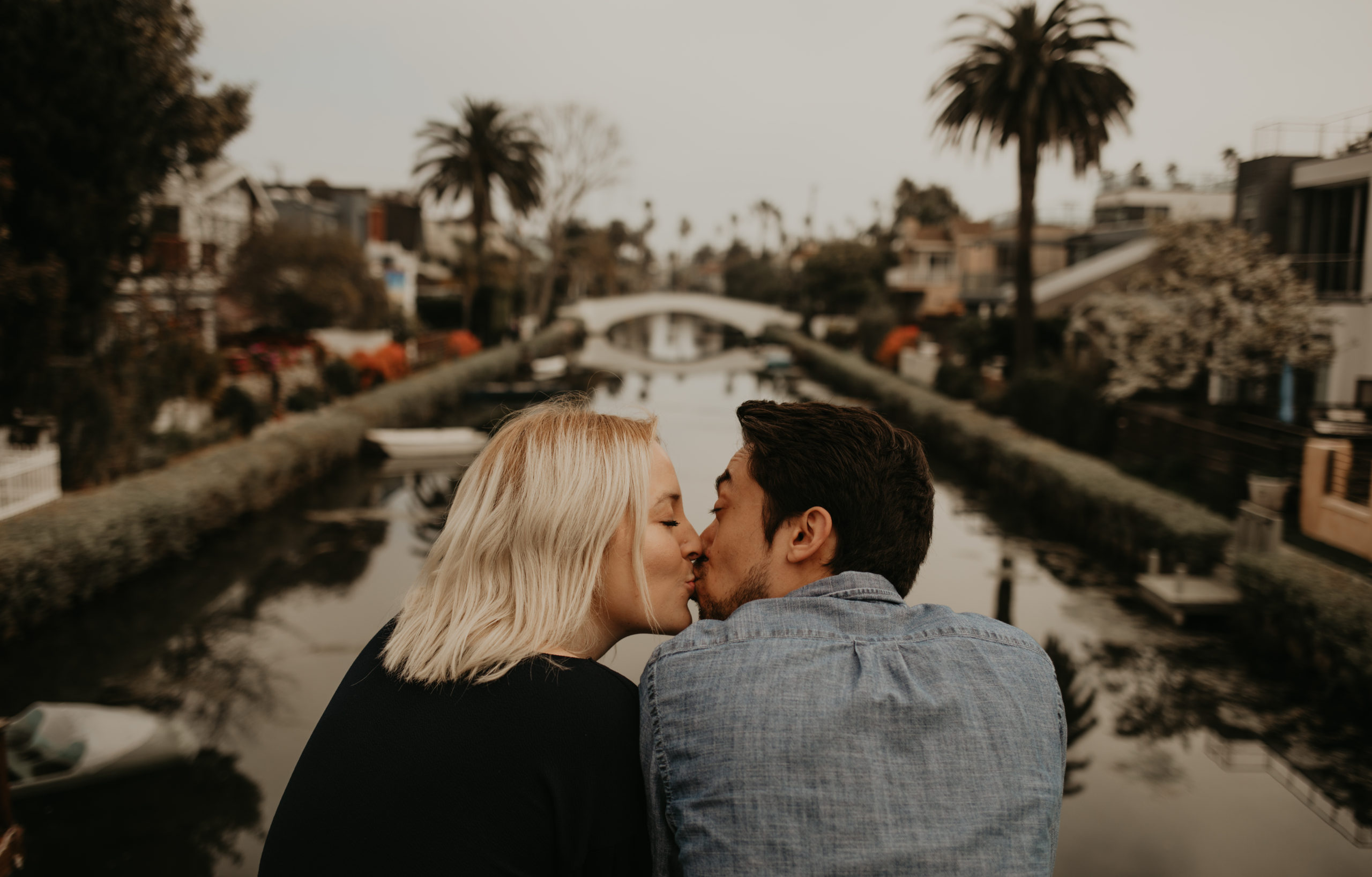 Micaela and Max kiss at Venice Canals, California with Cara Gilhula Photography